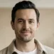 Portrait of a man with dark hair in a beige jacket