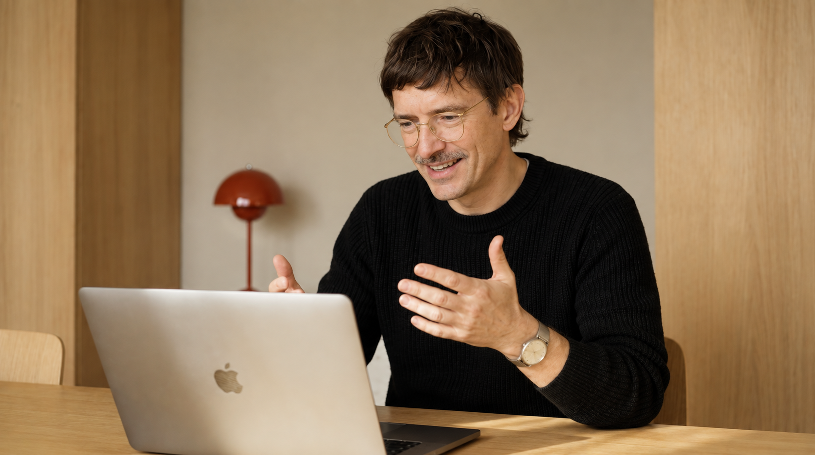 A man concentrating at a laptop in a pale minimal room